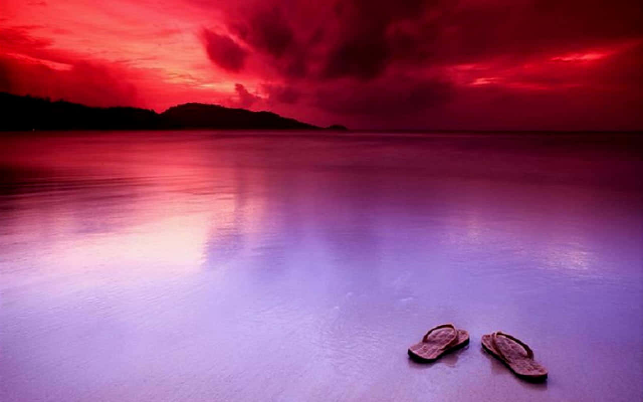 Colorful Beach Sandals On Sandy Shore Wallpaper