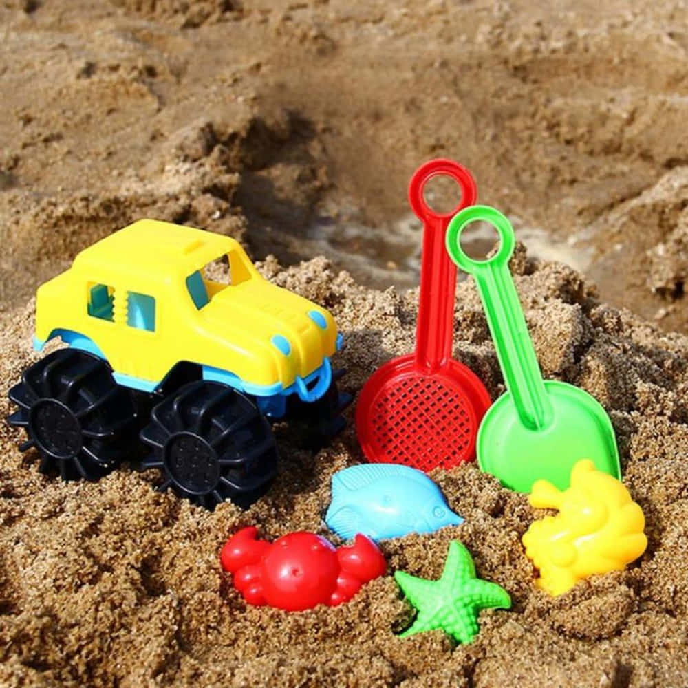 Colorful Beach Toys On Sandy Shore Wallpaper