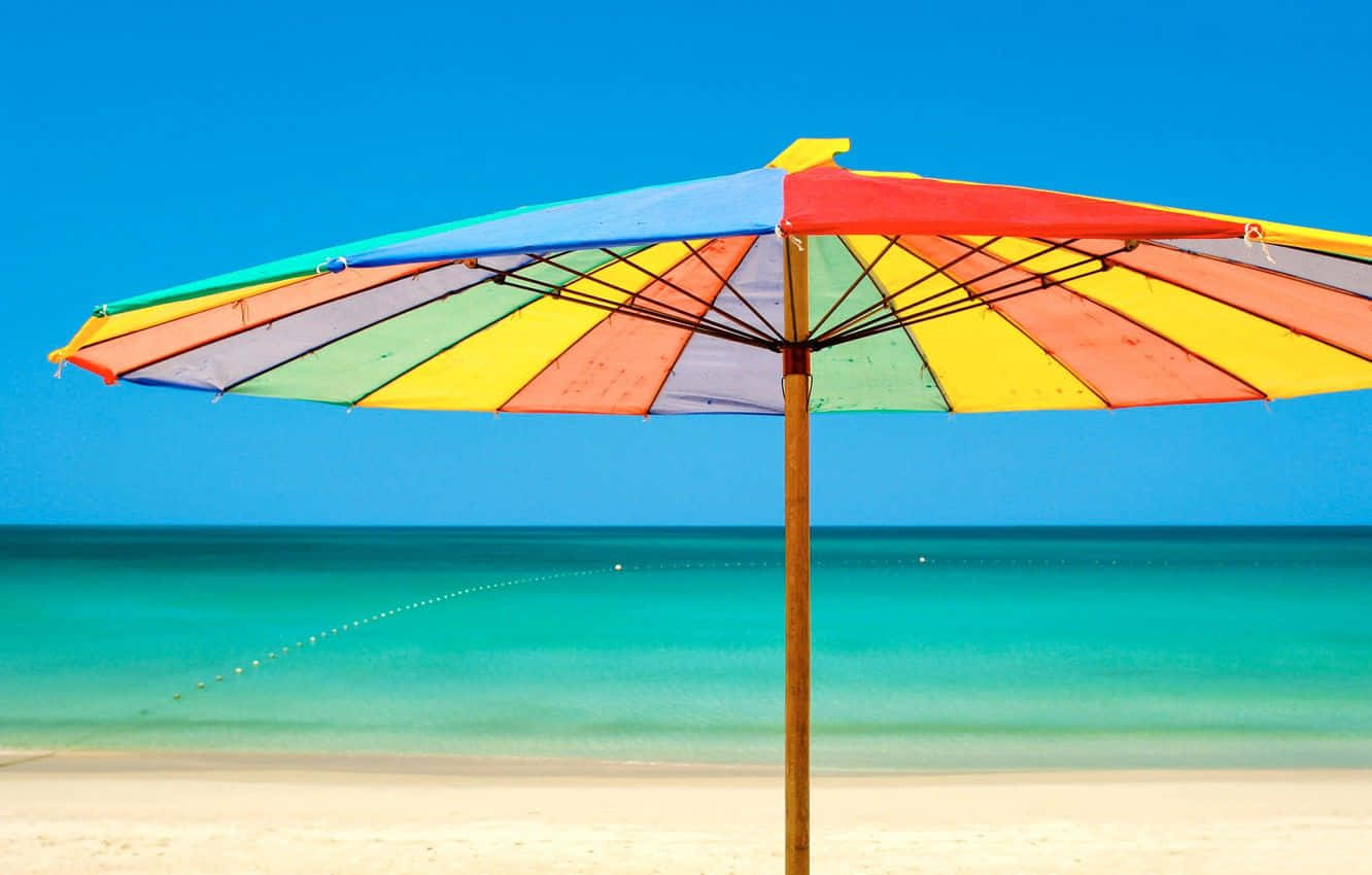 Colorful Beach Umbrella And Relaxing Ocean Waves Wallpaper