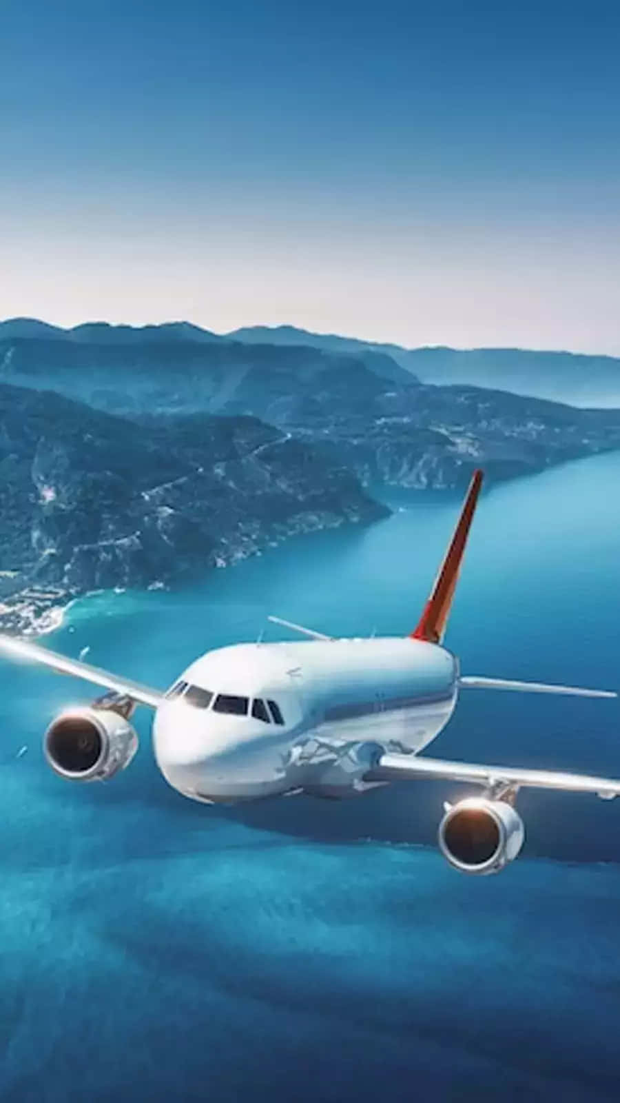 Commercial Airplane Over Coastal Landscape Wallpaper