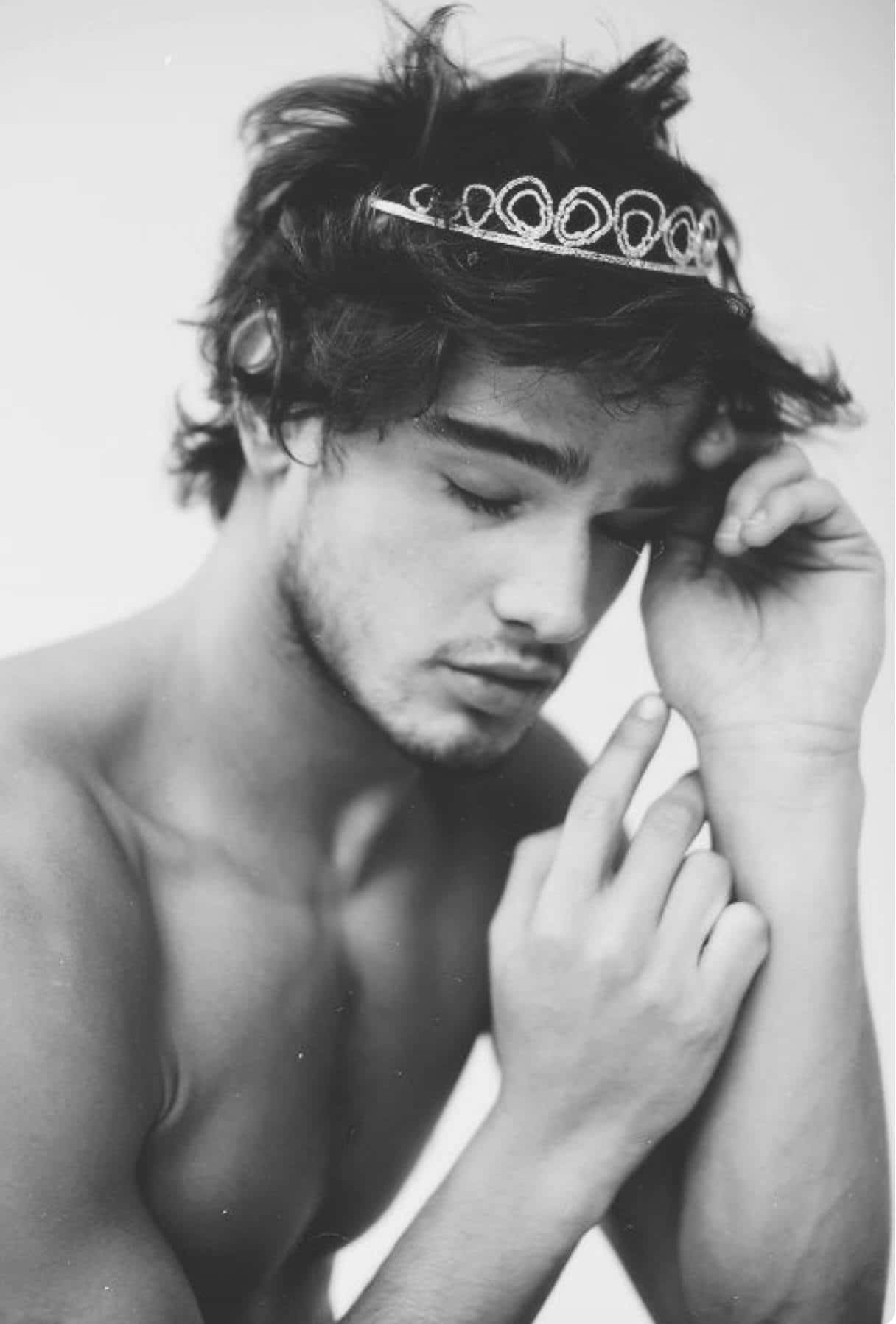 Contemplative Crown Wearing Young Man Wallpaper