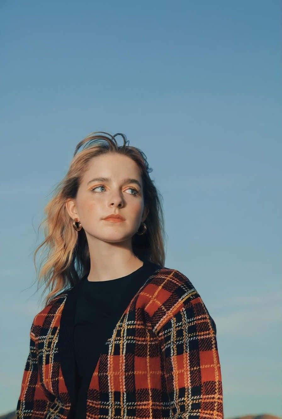 Contemplative Young Woman Against Blue Sky Wallpaper