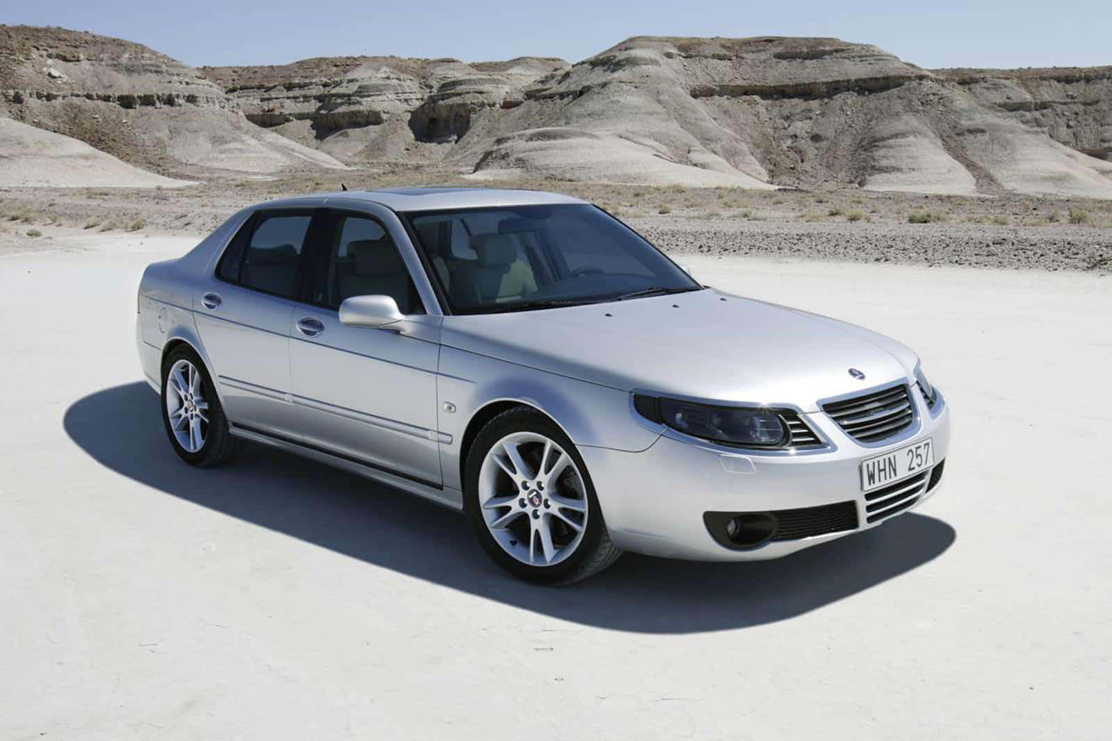 Cosmopolitan Silver Saab 9-5 Parked On City Streets In The Evening Wallpaper