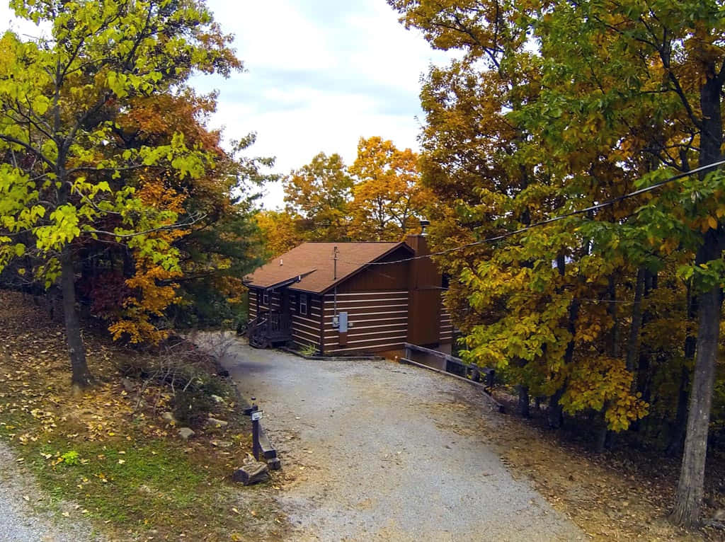 Cozy Fall Cabin Nestled In The Heart Of The Woods Wallpaper