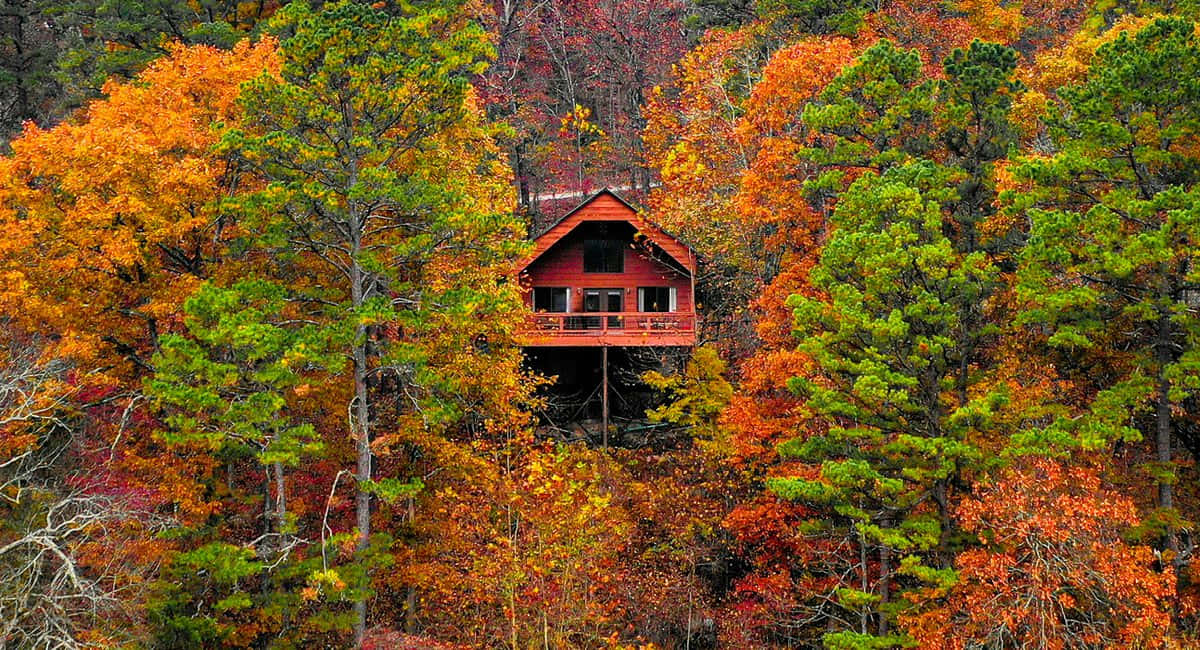 Cozy Fall Cabin Surrounded By Autumn Foliage Wallpaper