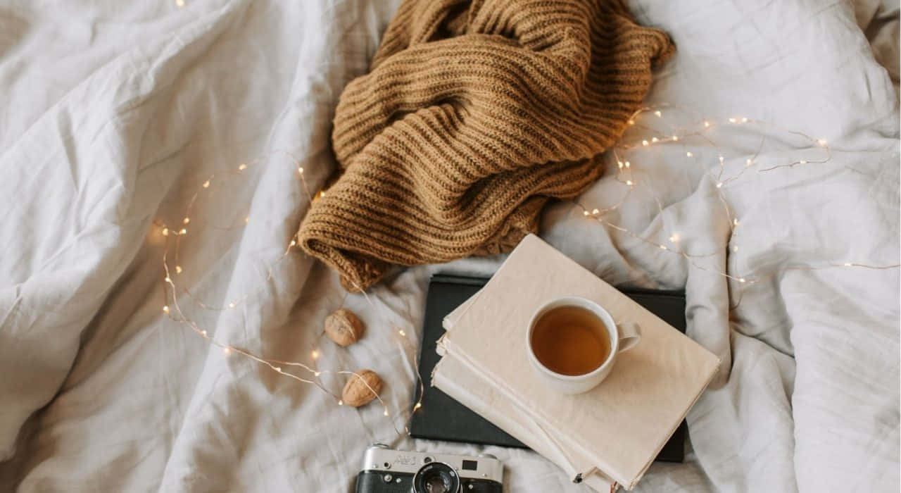 Cozy Tea Timewith Booksand Lights Wallpaper