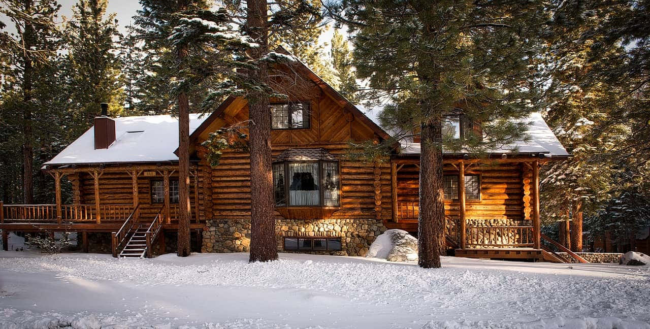 Cozy Winter Cabin In Snowy Forest Wallpaper