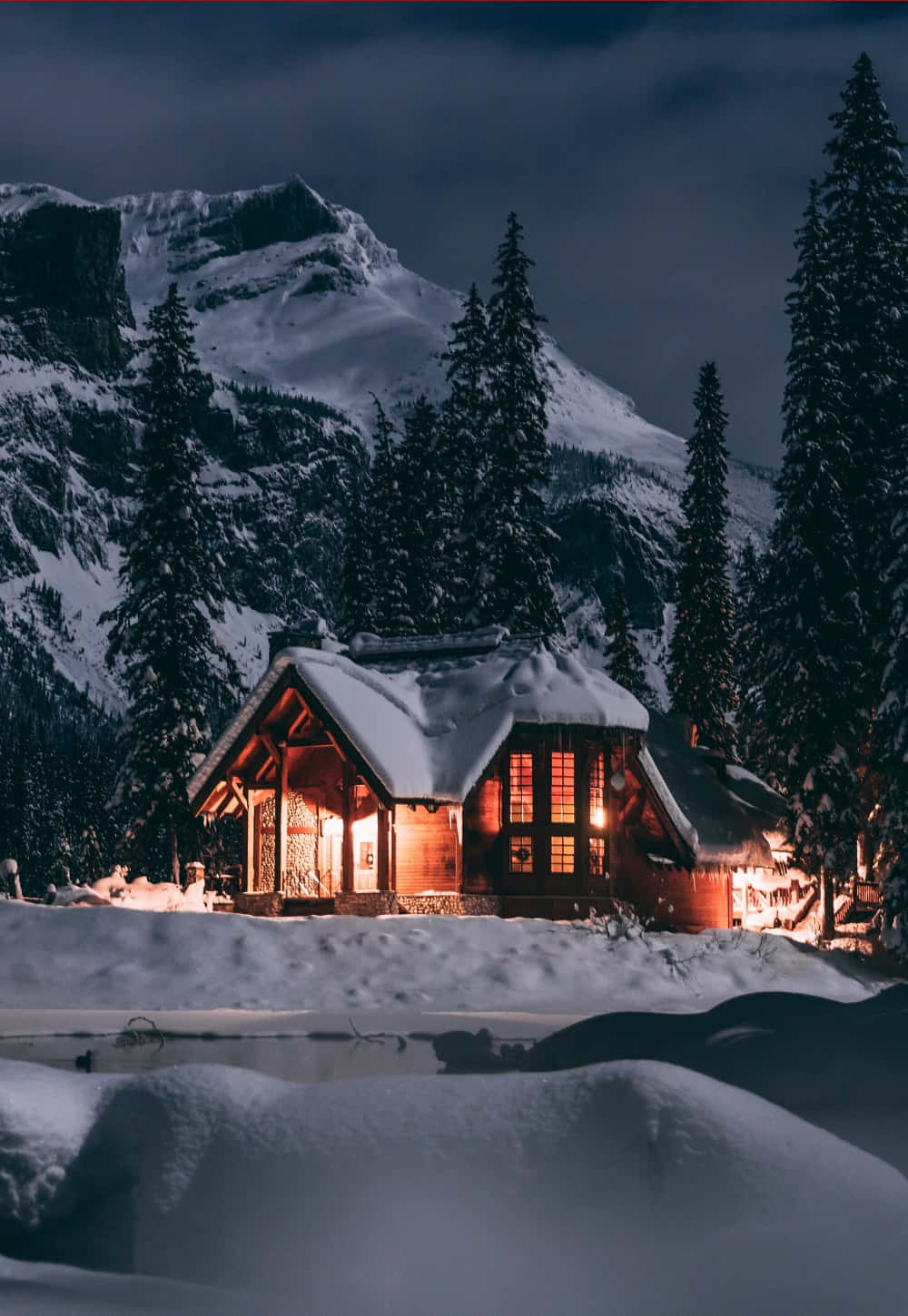 Cozy Winter Cabin Nestled In Snowy Woods Wallpaper