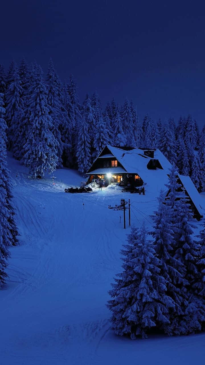 Cozy Winter Cabin Surrounded By Snow Wallpaper