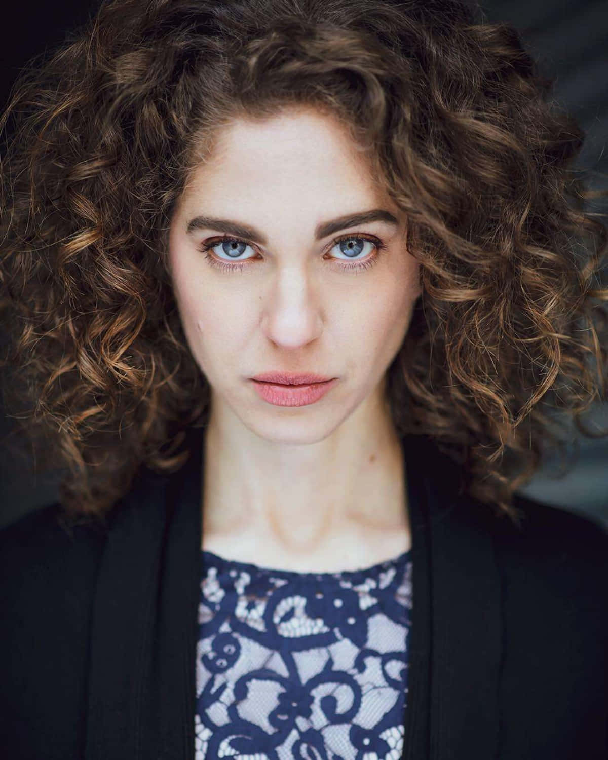 Curly Haired Woman Intense Gaze.jpg Wallpaper