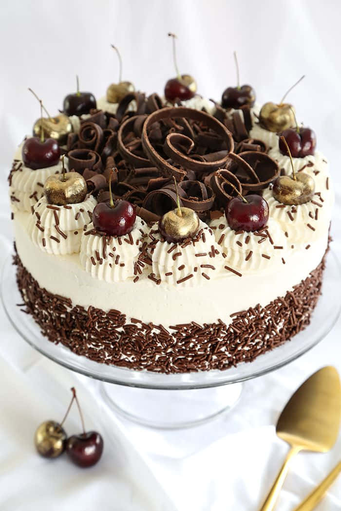 Delicious Black Forest Cake With Whipped Cream And Cherries Wallpaper