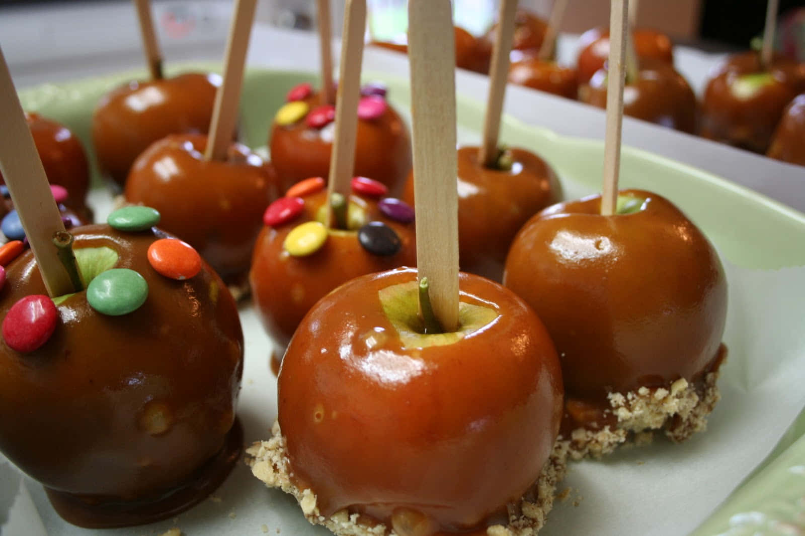 Delicious Caramel Apples On A Wooden Table Wallpaper