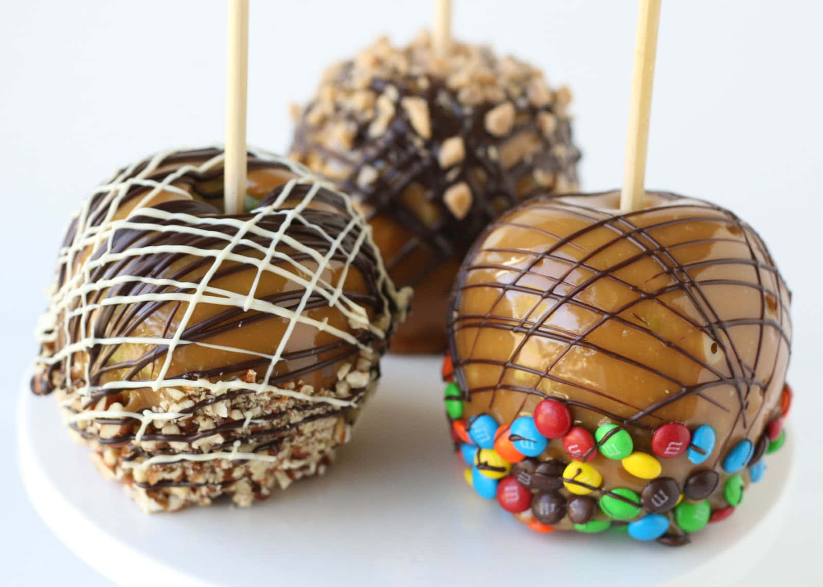 Delicious Homemade Caramel Apples With Nuts And Chocolate Drizzle Wallpaper