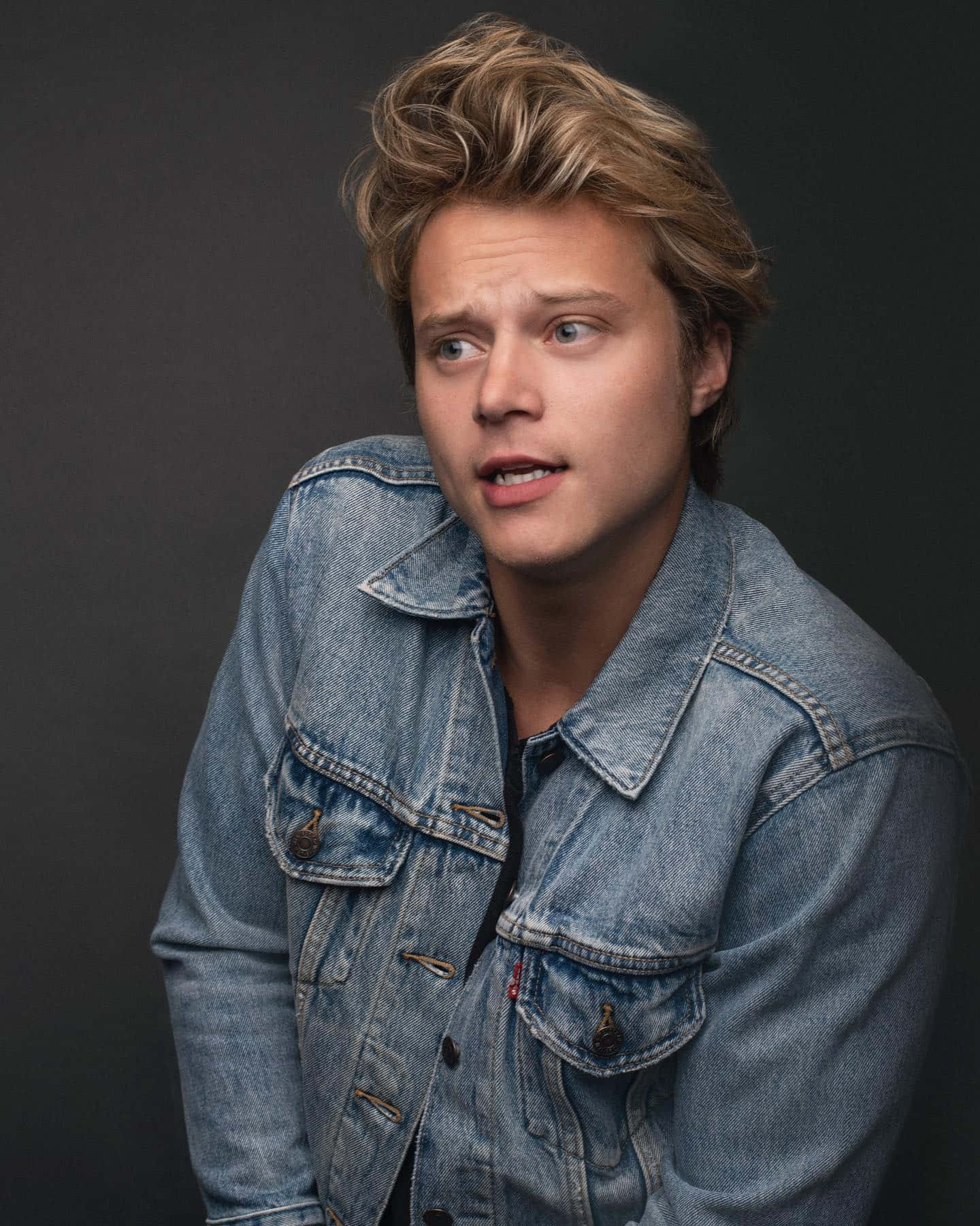 Denim Clad Young Man Looking Pensive Wallpaper