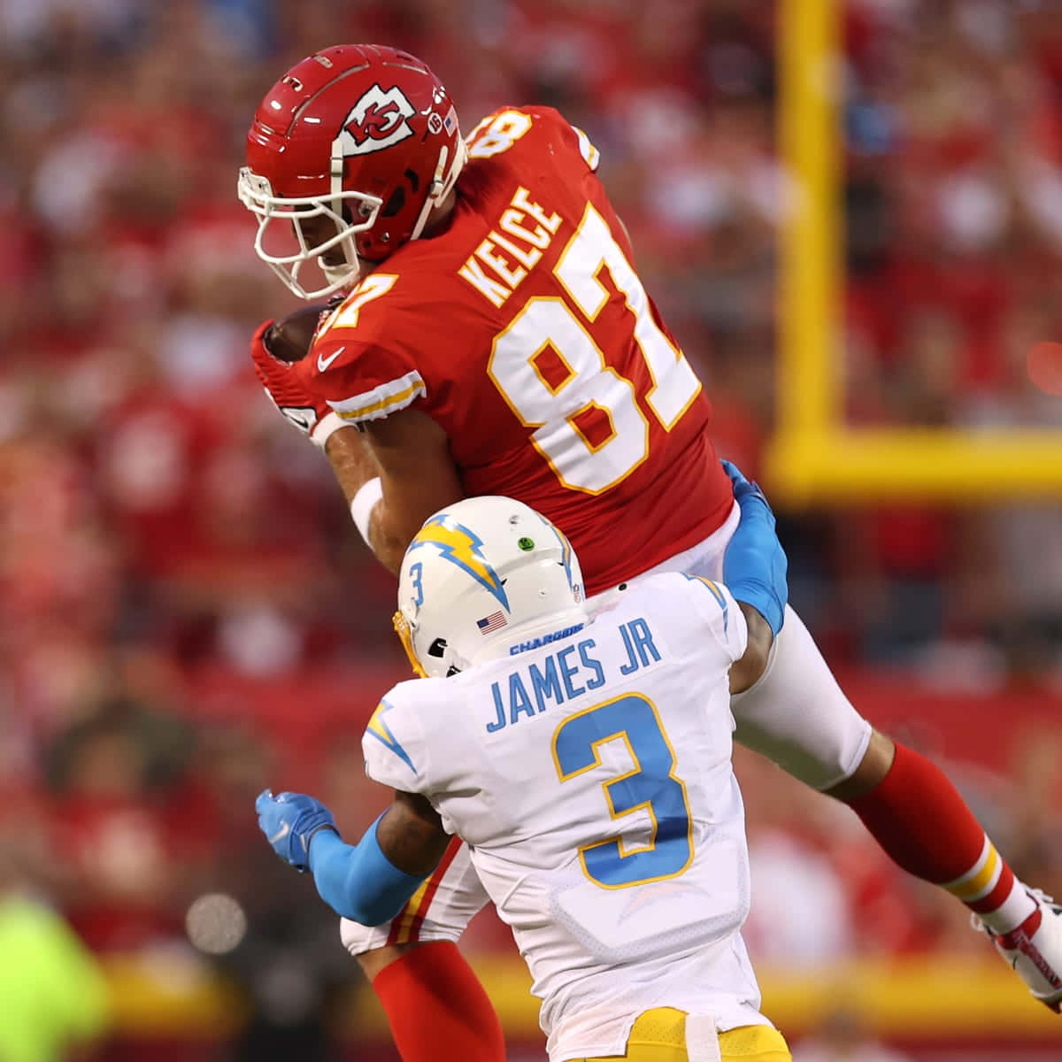 Derwin James Tackling Travis Kelce Football Player Wallpaper