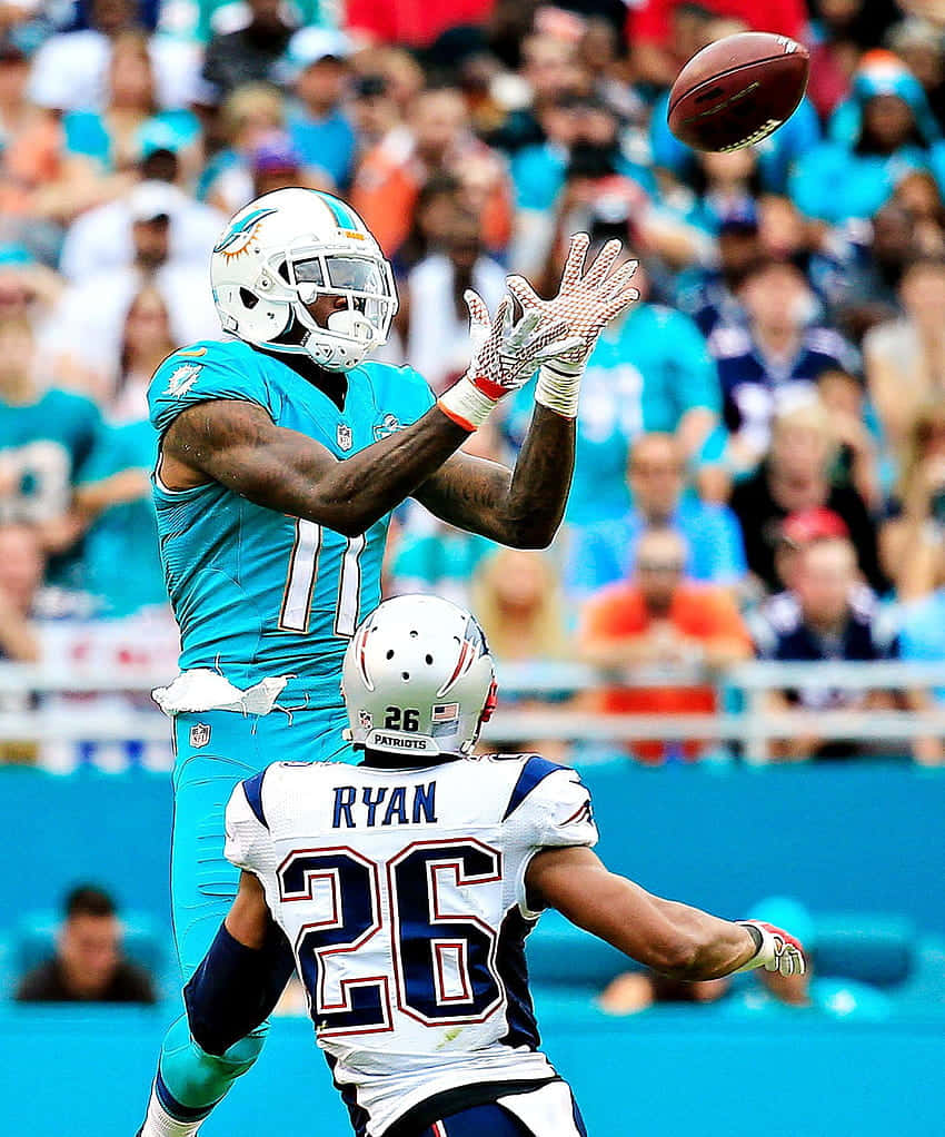 Devante Parker Catching Football Against Defender Wallpaper