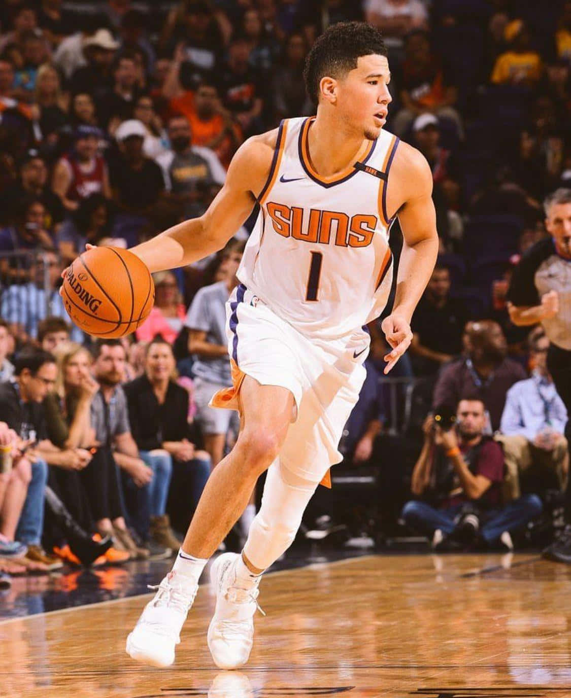 Devin Booker Glistening Mid-game In A Phoenix Suns Jersey. Wallpaper