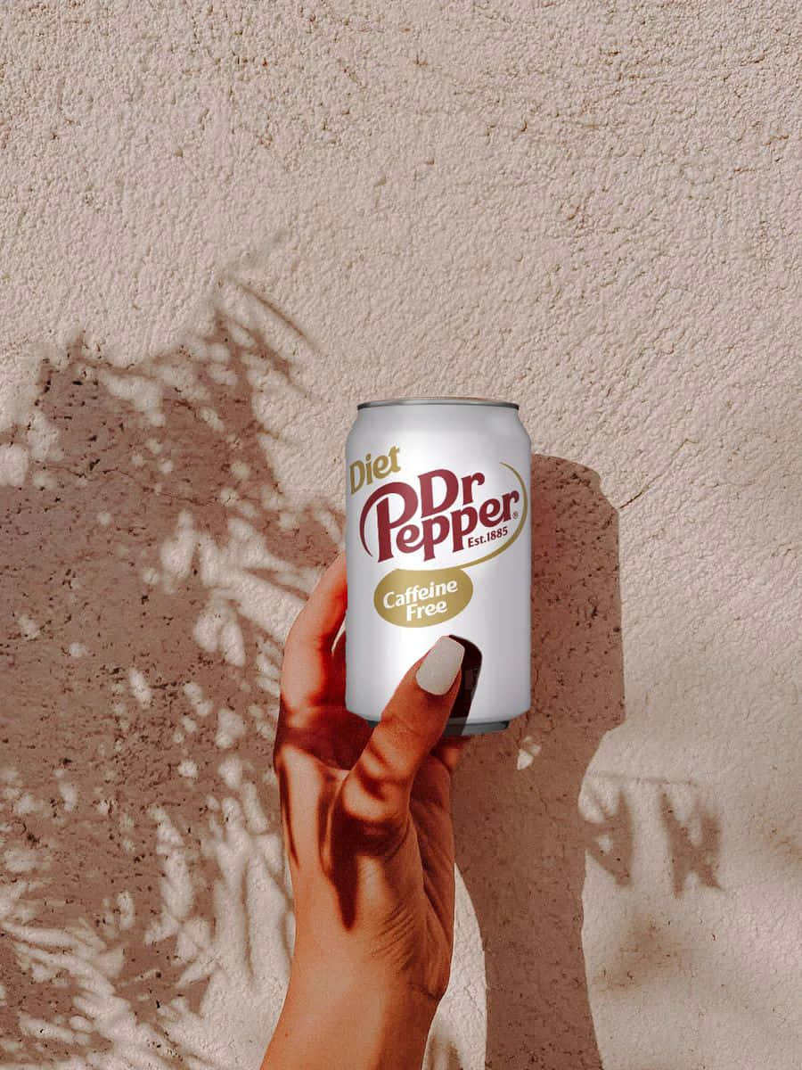 Diet Dr Pepper Caffeine Free Can Held Against Sunlit Wall Wallpaper