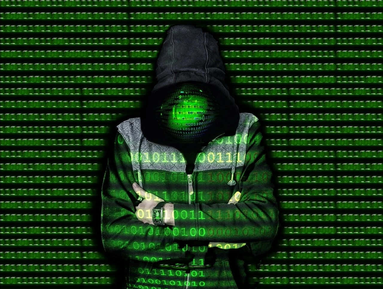 Digital_ Hooded_ Figure_in_ Matrix_ Code_ Background.jpg Wallpaper