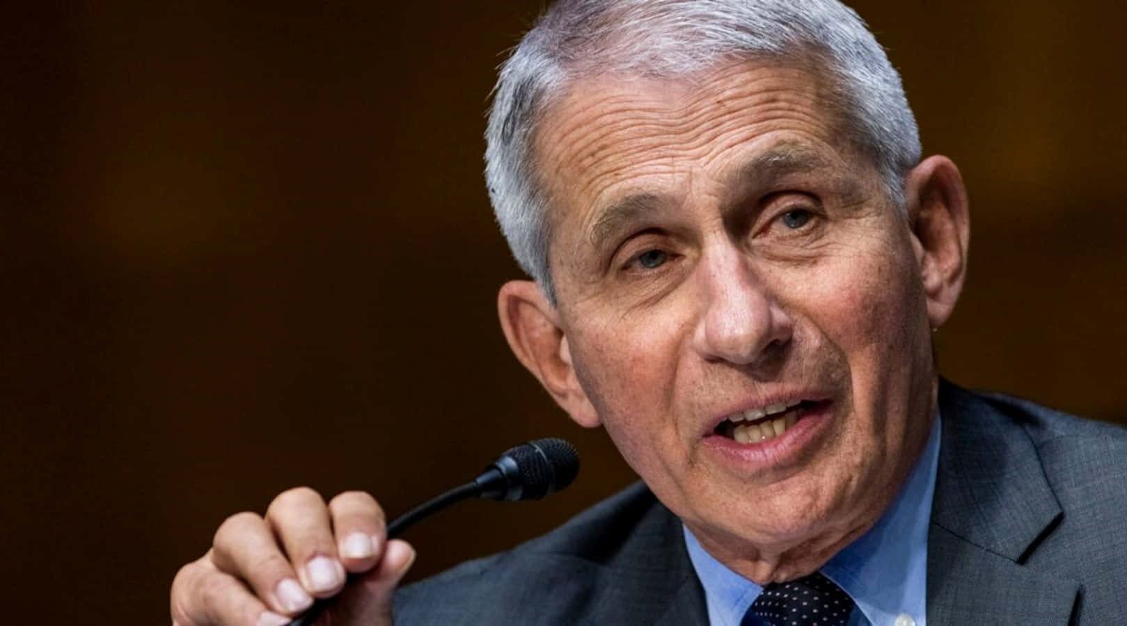 Dr. Anthony Fauci In Deep Thought At His Office Wallpaper