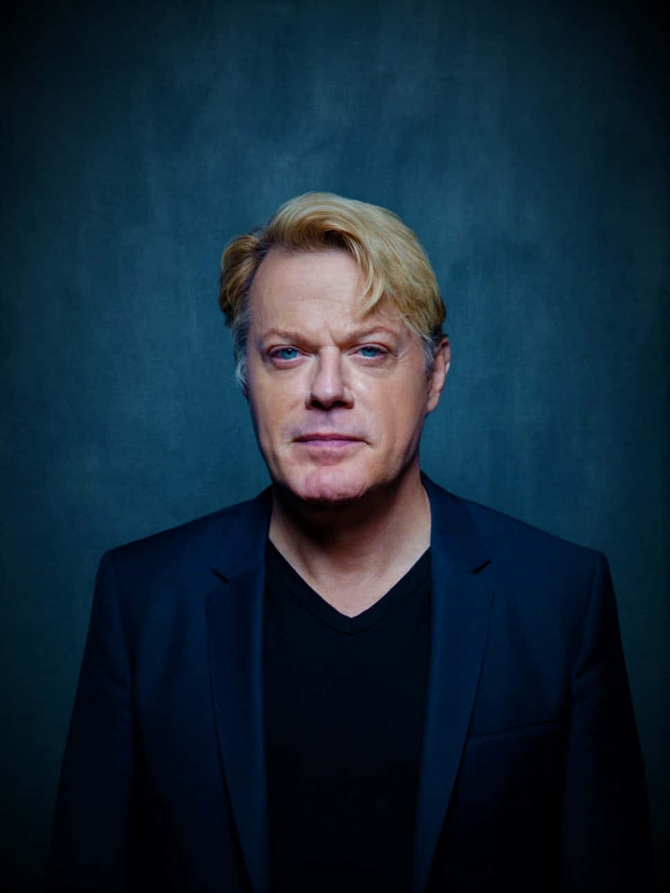 Eddie Izzard Striking A Pose On Stage Wallpaper