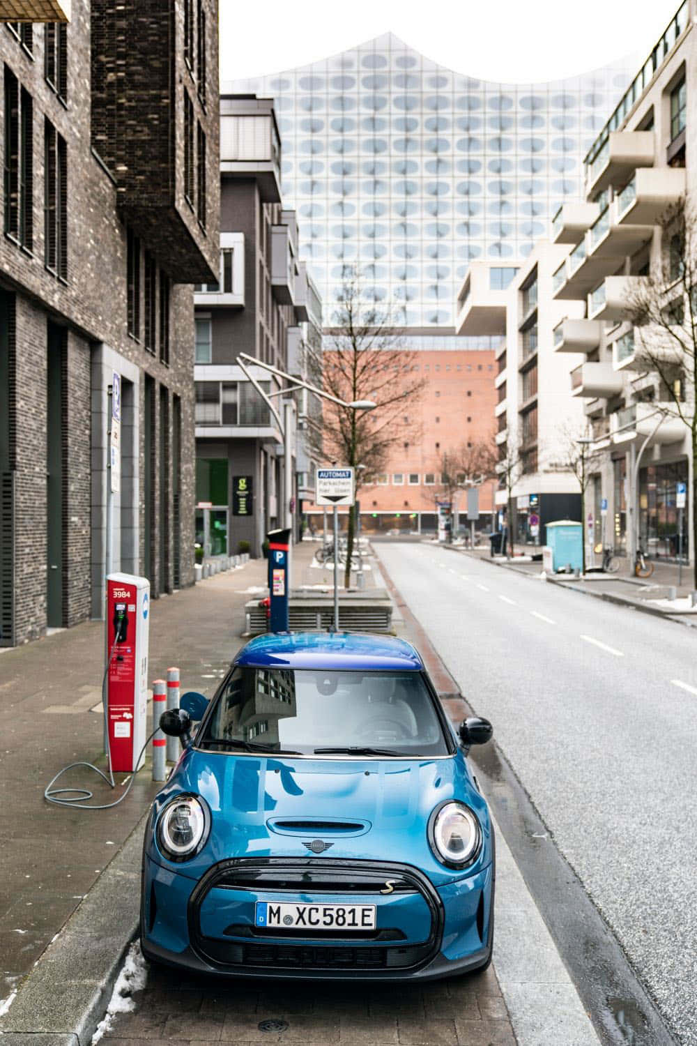 Electric Mini Cooper S E Chargingin Urban Setting Wallpaper