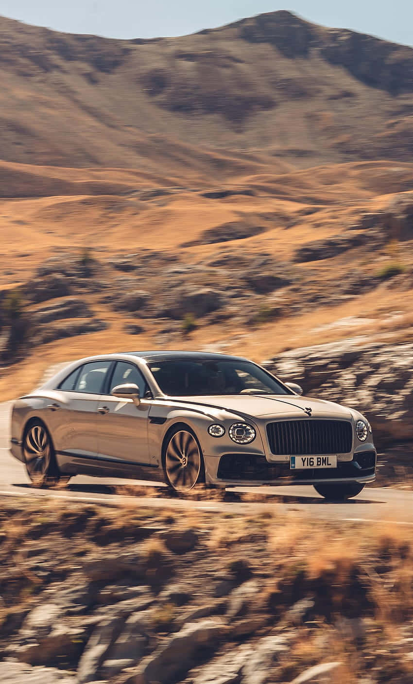 Elegant Bentley Flying Spur Cruising On The Road Wallpaper