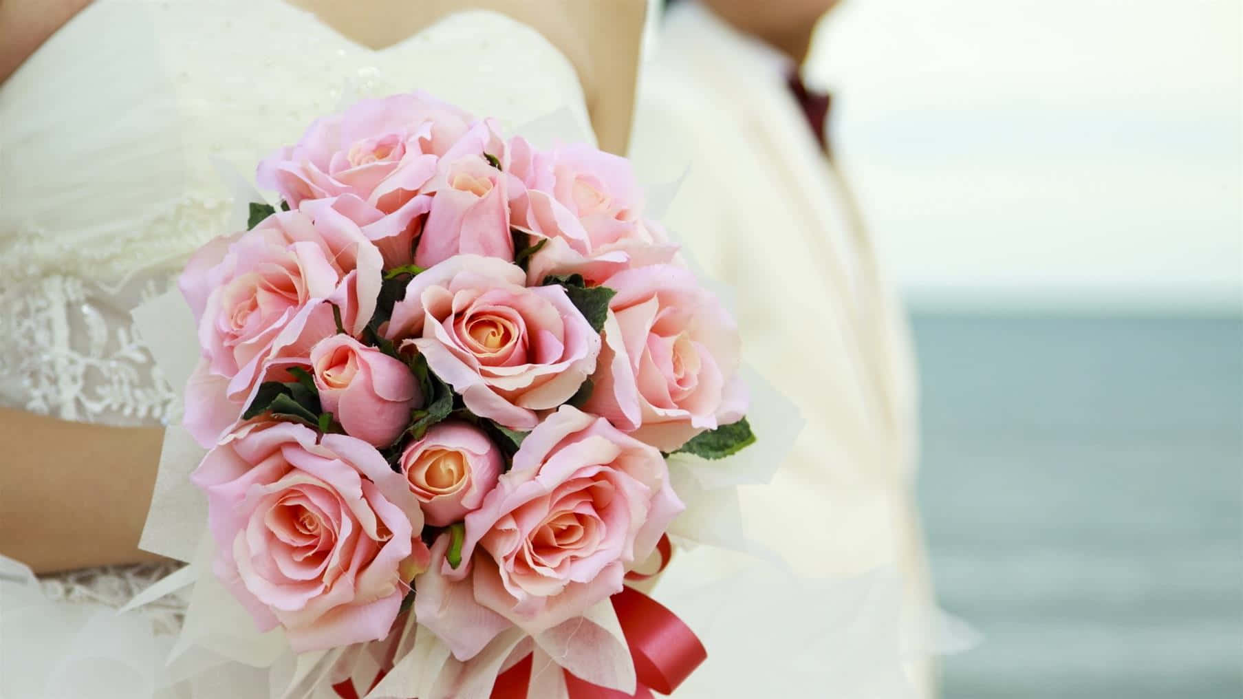 Elegant Bride Holding A Beautiful Floral Wedding Bouquet Wallpaper