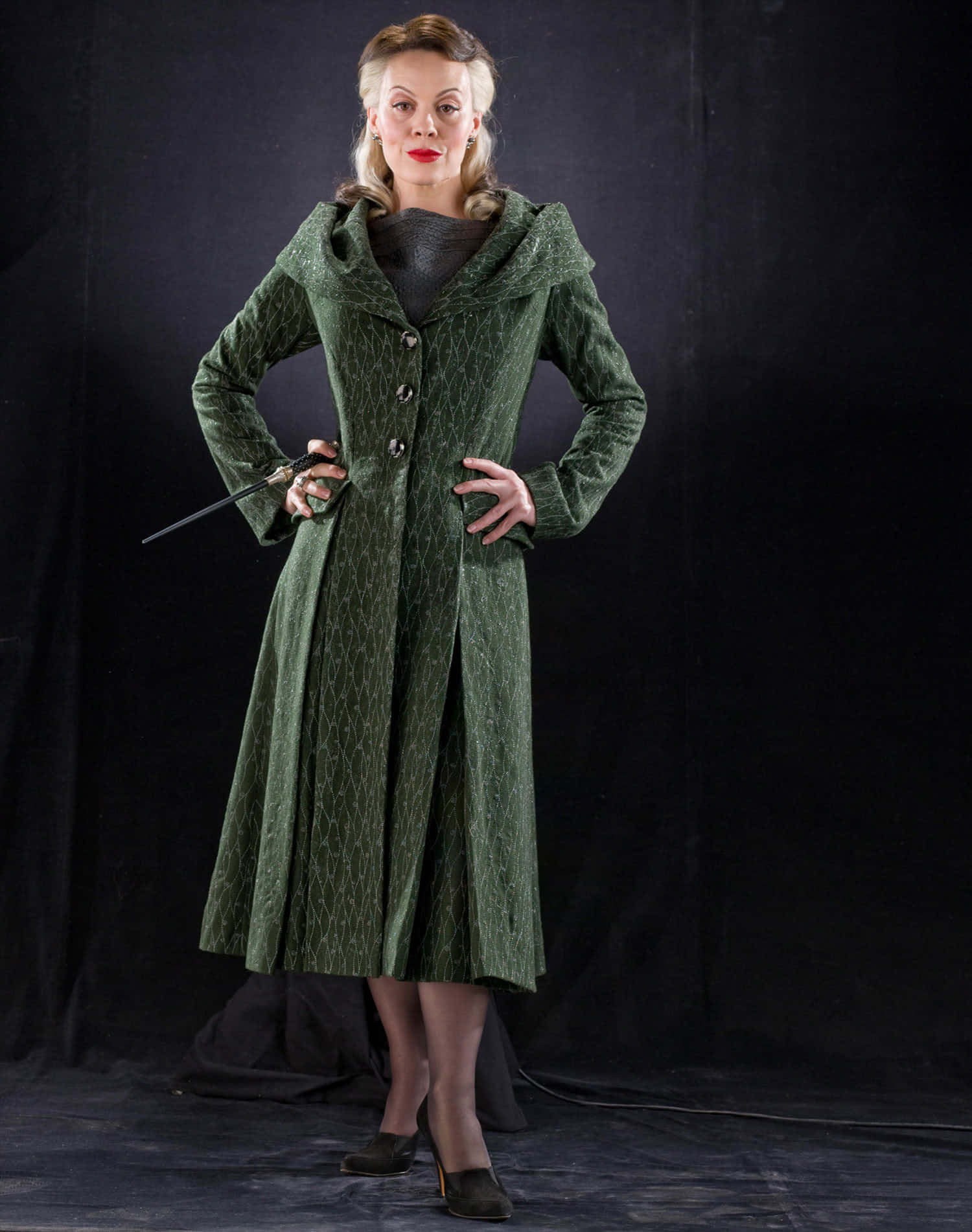 Elegant Womanin Green Coatwith Wand Wallpaper