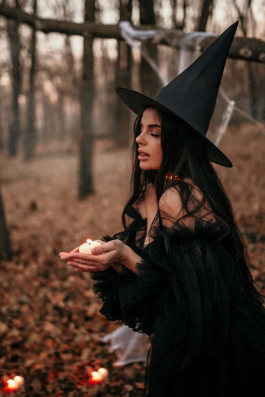 Enchanting Witch Casting A Spell In A Stylish Costume Wallpaper