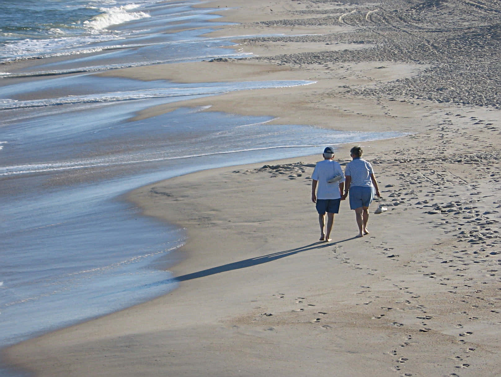 Enjoying A Peaceful Walk On A Picturesque Beach At Sunset. Wallpaper