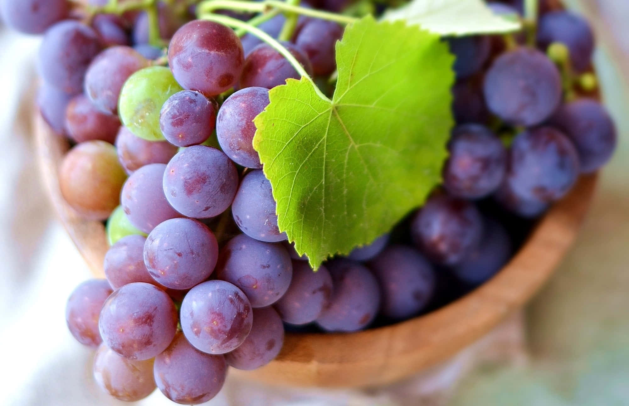 Enjoying The Sweetness Of Purple Grapes Wallpaper