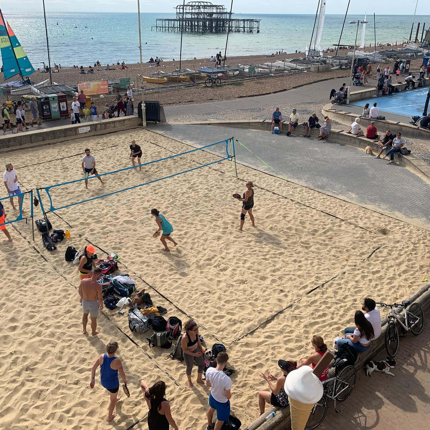 Exciting Beach Tennis Match At Sunset Wallpaper