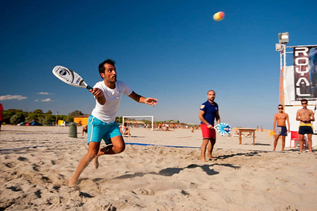 Exciting Beach Tennis Match In Action Wallpaper