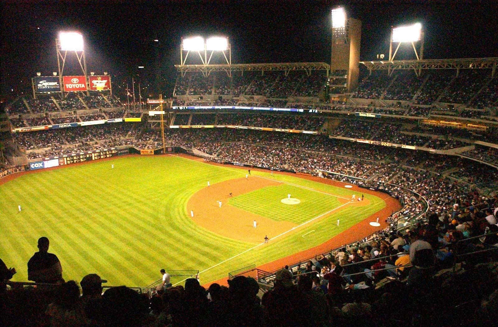 Exciting Night Game At A Bustling Baseball Stadium Wallpaper