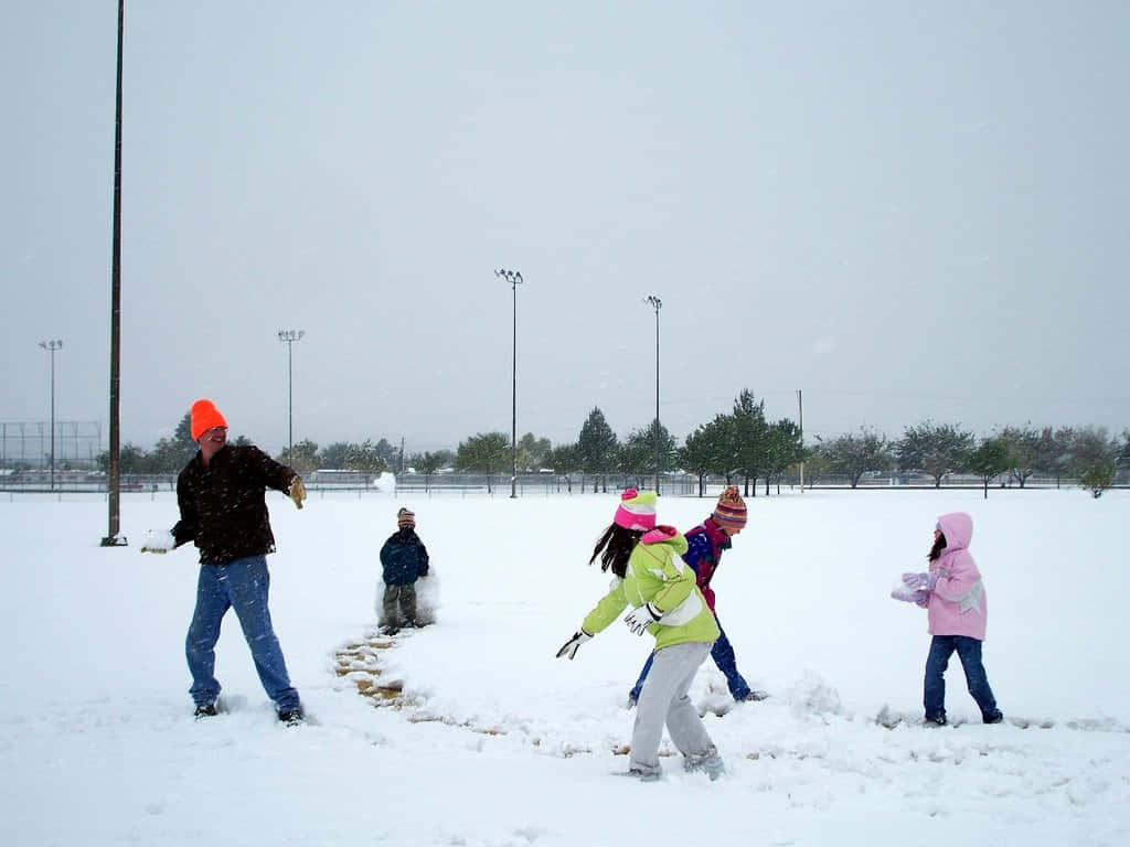 Exciting Snowball Fight On A Snowy Winter Day Wallpaper