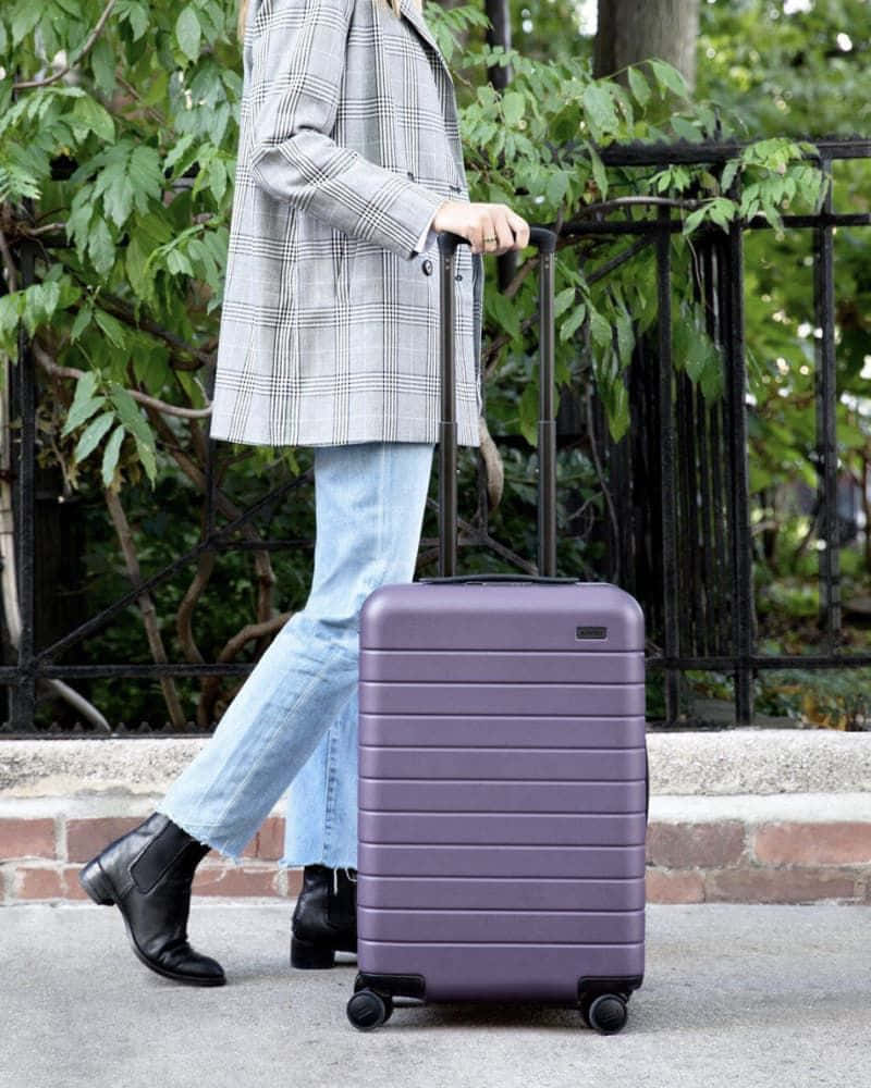 Explore The World In Style With Purple Suitcase Wallpaper