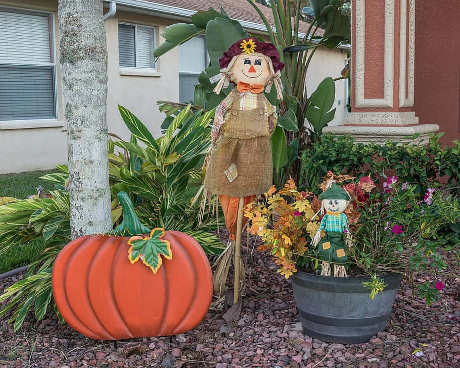 Fall Scarecrow Standing Tall In A Vibrant Autumn Field Wallpaper