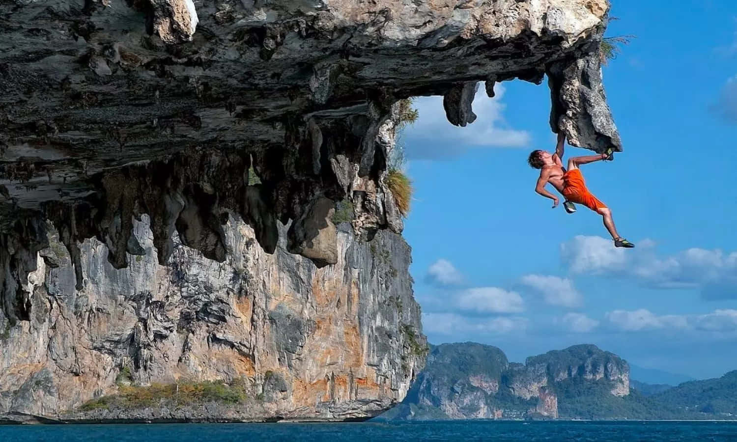 Fearless Adventurer Standing At The Edge Of A Mountain Cliff Wallpaper