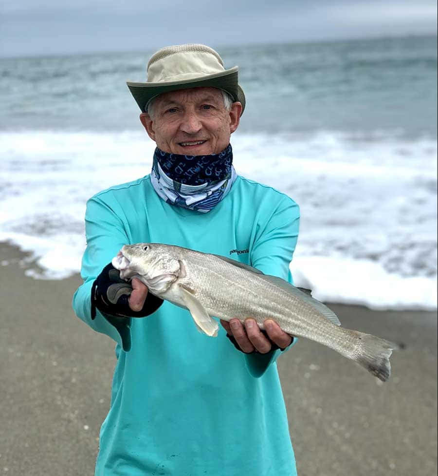 Fishermanwith Caught Whitingat Beach Wallpaper