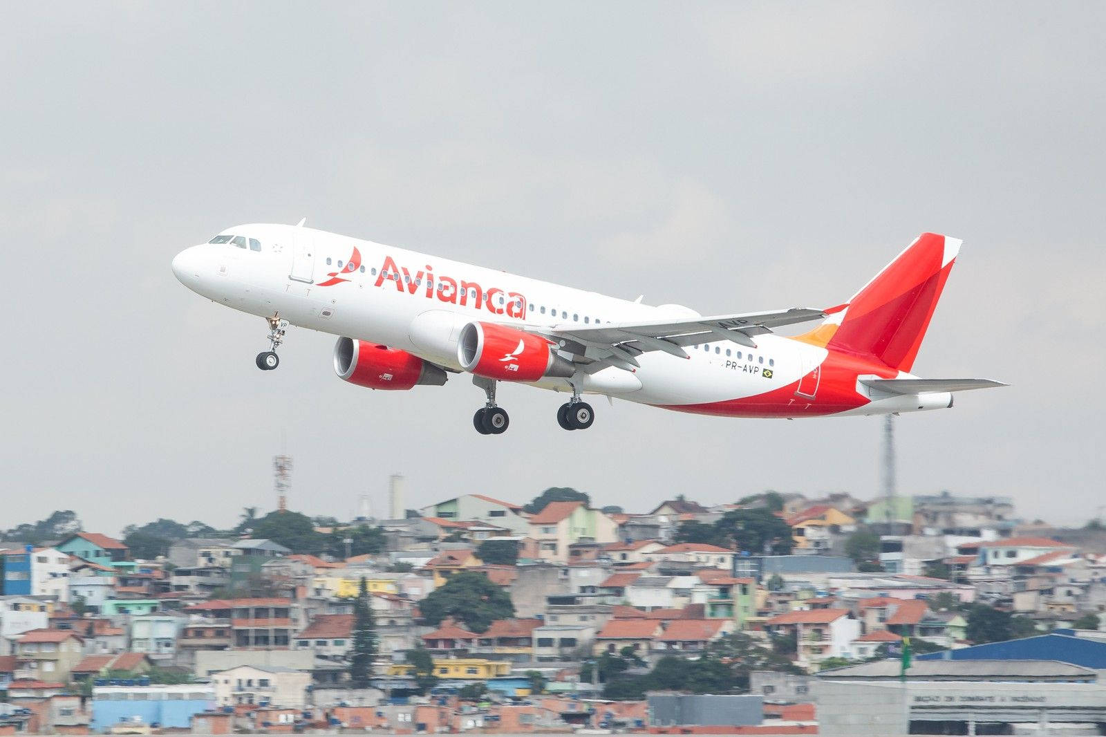 Flying Avianca Brasil Airline Airbus Over Houses Wallpaper