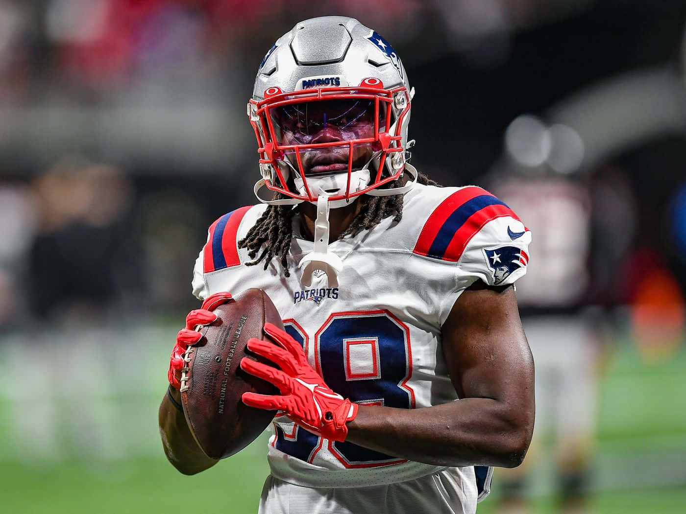 Focused Football Player Holding Ball Wallpaper