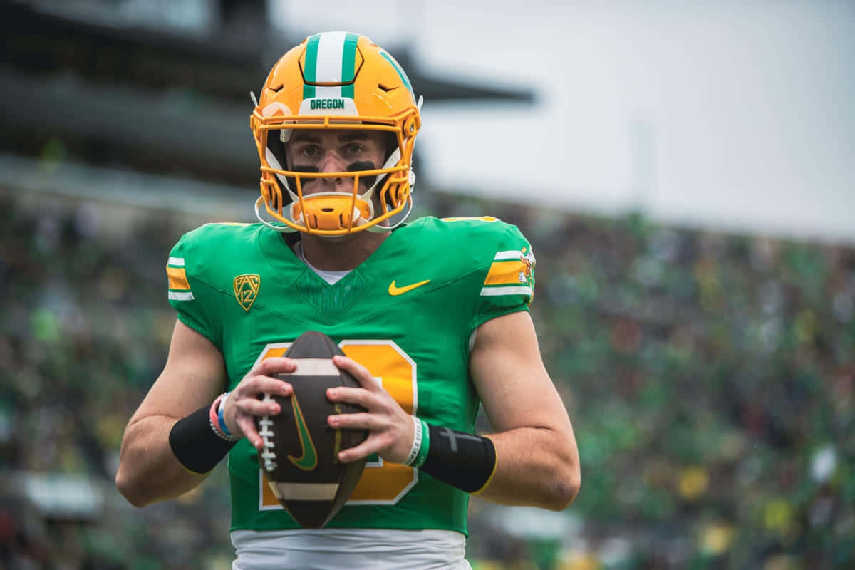 Focused Football Player Holding Ball Wallpaper