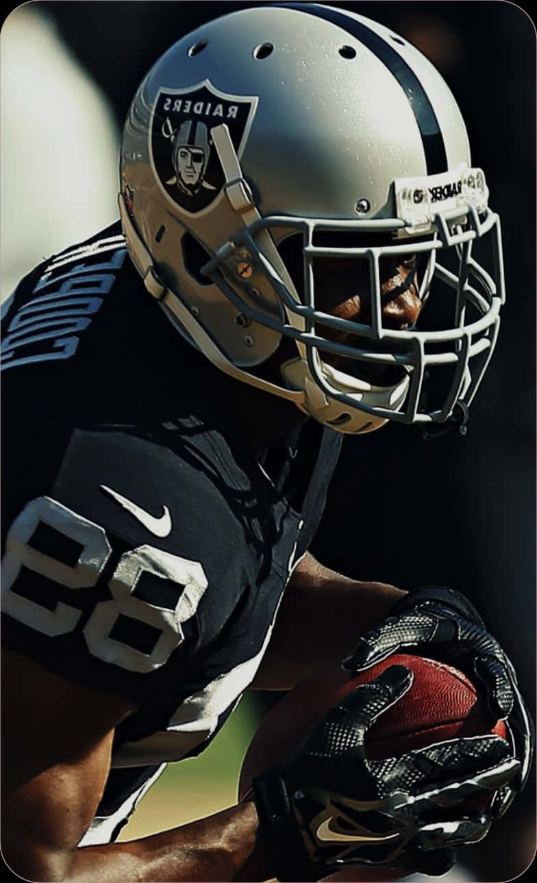 Focused Raiders Player Holding Football Wallpaper