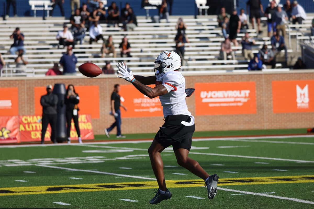 Football Player Catching Ball During Game Wallpaper