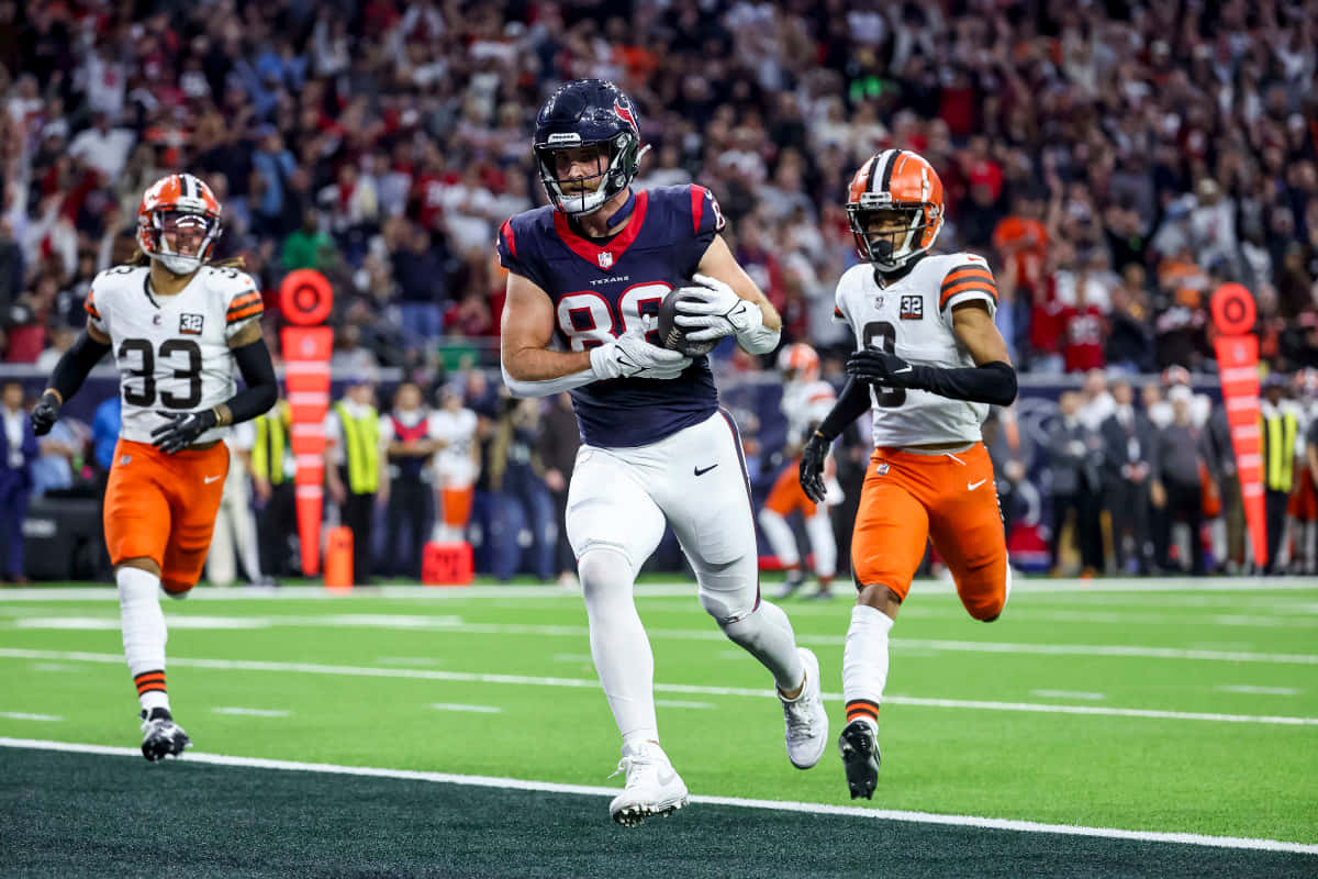 Football Player Catching Ball During Game Wallpaper