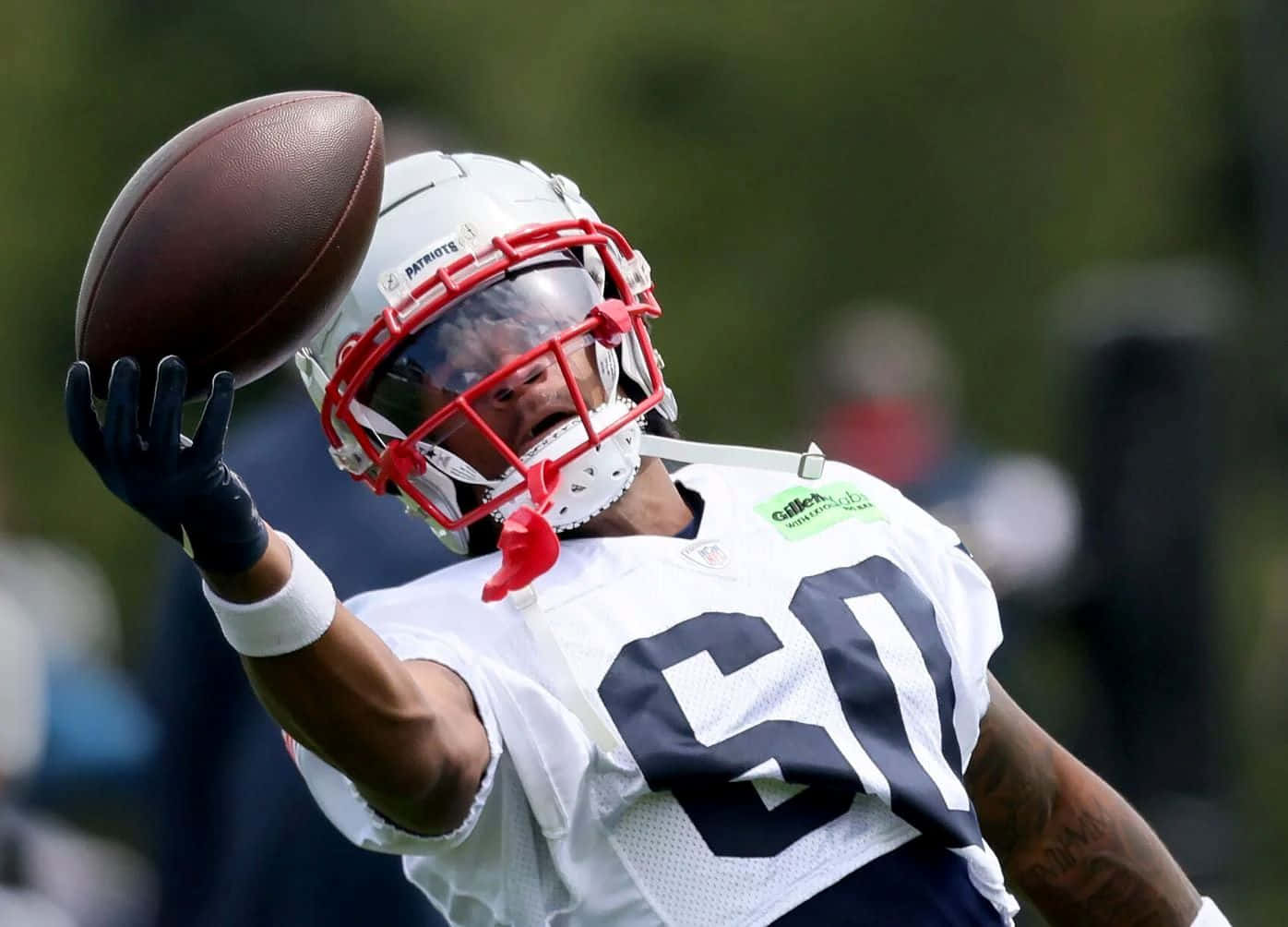 Football Player Catching Ball During Practice Wallpaper