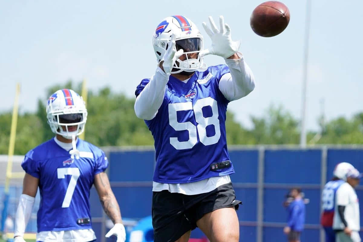 Football Player Catching Ball During Practice Wallpaper