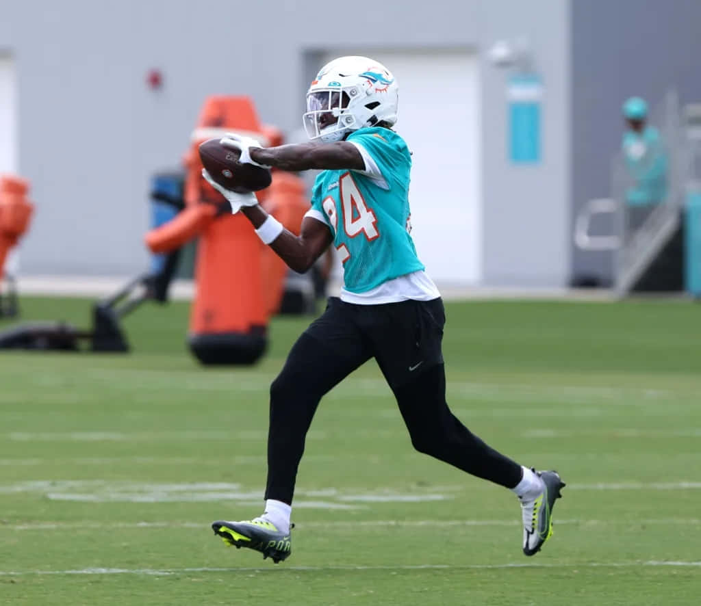 Football Player Catching Ball During Practice Wallpaper