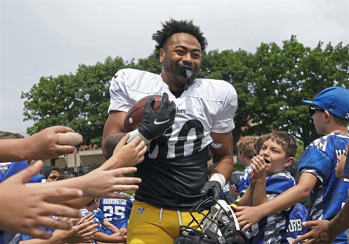 Football Player High Fiving Young Fans Wallpaper